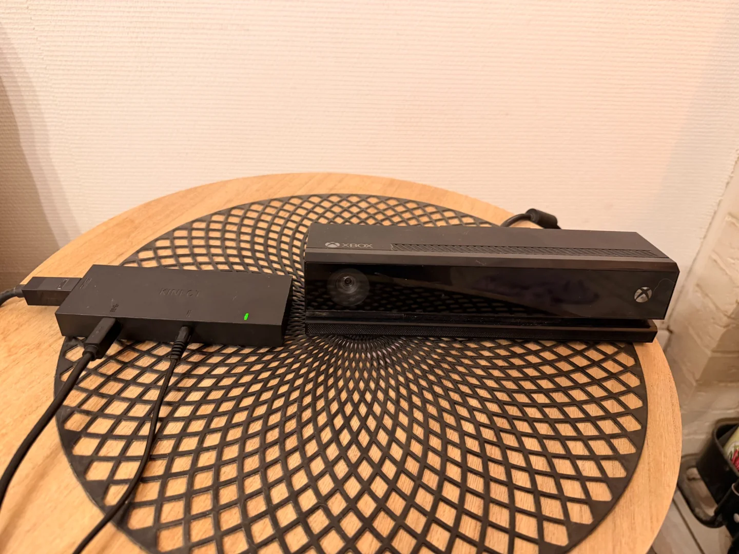 Xbox One Kinect v2 beside its powered USB adapter on a table
